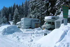 Feriencamping Hochschwarzwald - Schneebedeckte Wohnwagen in winterlicher Berglandschaft