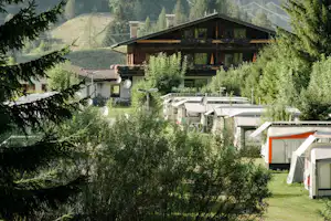 Feriencenter Biberhof - Der Wohnwagen- und Zeltstellplatz mit dem Hauptgebäude des Campingplatzes im Hintergrund