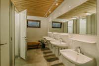 Feriencenter Biberhof - Innenraum des Sanitärgebäudes mit Toilettenkabinen, Waschbecken und Spiegeln