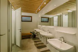 Feriencenter Biberhof - Innenraum des Sanitärgebäudes mit Toilettenkabinen, Waschbecken und Spiegeln
