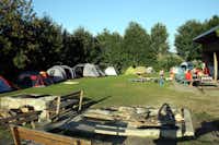 Ferienhof Schiermeier - Zeltwiese umringt von Bäumen mit Lagerfeuerstelle und Picknicktische