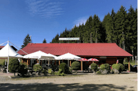 Ferienpark Birnbaumteich - Restaurant mit Terrasse und Sonnenschirmen auf dem Campingplatz am Wald