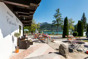 Ferienpark Terrassencamping Süd-See - Restaurant mit Terrasse und Sonnenschirmen auf dem Campingplatz direkt am See mit Bergblick