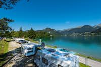 Ferienpark Terrassencamping Süd-See - Stellplätze im Schatten unter Bäumen am See auf dem Campingplatz mit Alpenblick