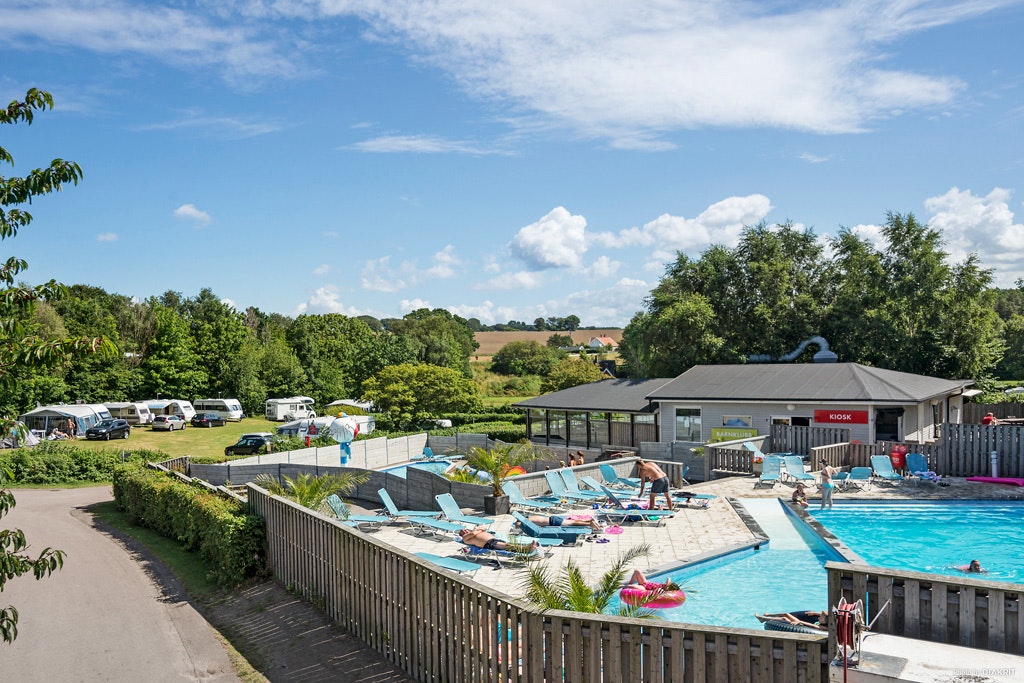 First Camp Mölle- Campingplatzanlage mit Kiosk und mit Pool und Liegestühlen in der Sonne