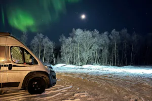 Fjordutsikten Motell & Camping AS - Standplatz im Schnee mit Polarlichtern am Himmel