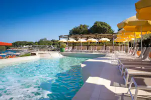 FKK-Camping Valalta - Poolbereich mit Liegestühlen und Sonnenschirmen auf dem Campingplatz