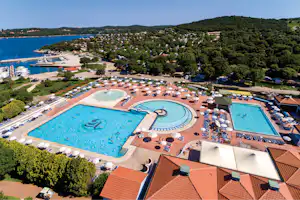 FKK-Camping Valalta - Poolbereich vom Campingplatz mit Planschbecken Liegestühlen und Sonnenschirmen aus der Vogelperspektive