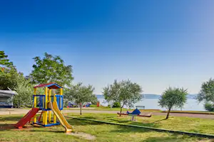 Camping Kanegra - Spielplatz mit Blick auf das Meer auf dem Campingplatz