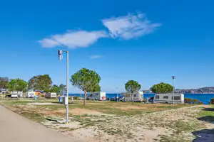 Camping Kanegra - Stellplatz für Wohnwagen auf dem Rasen mit dem Blick auf das Meer