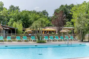 Flower Camping La Clairière - Pool im Freien mit Liegestühlen und Sonnenschirmen