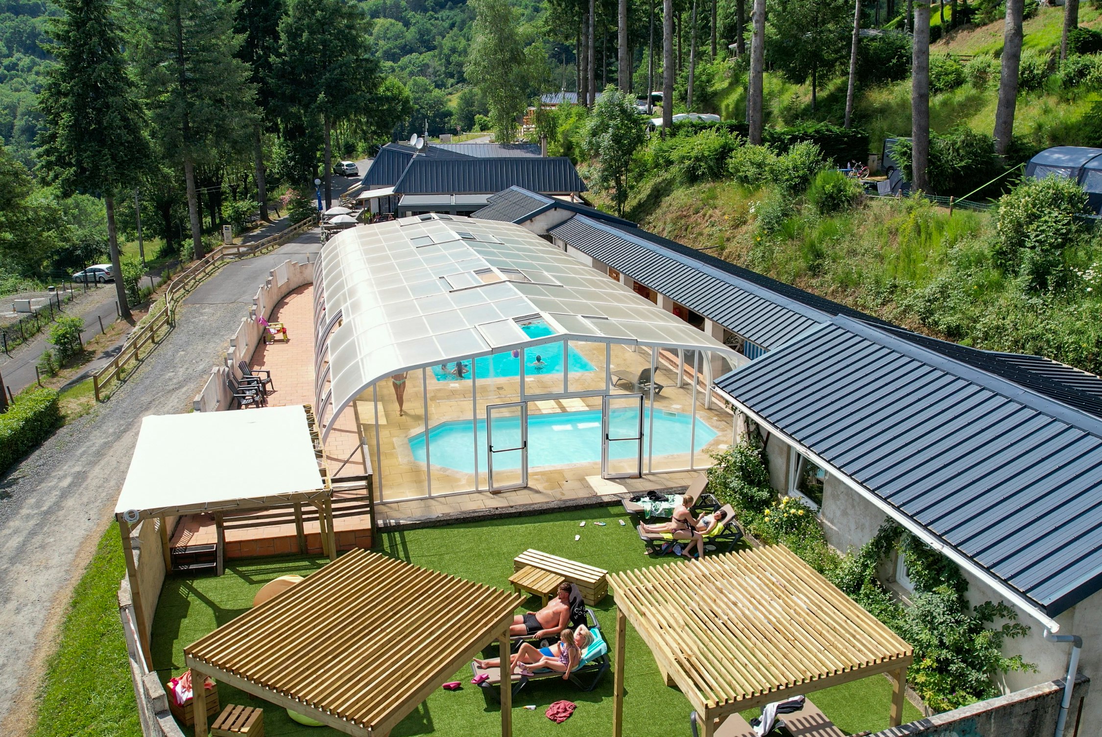 Flower Camping Le Belvédère - Überdachter Pool und Liegewiese auf dem Campingplatz