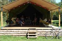 Flower Camping Les 3 Ours - Mobilheim vom Campingplatz mit Liegestühlen, Hängematte, Fahrrad und Grill auf der Veranda