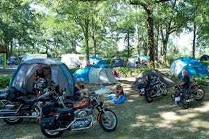 Camping des Étangs Flower Camping Les Étangs - Camper mit Motorrädern auf der Zeltwiese