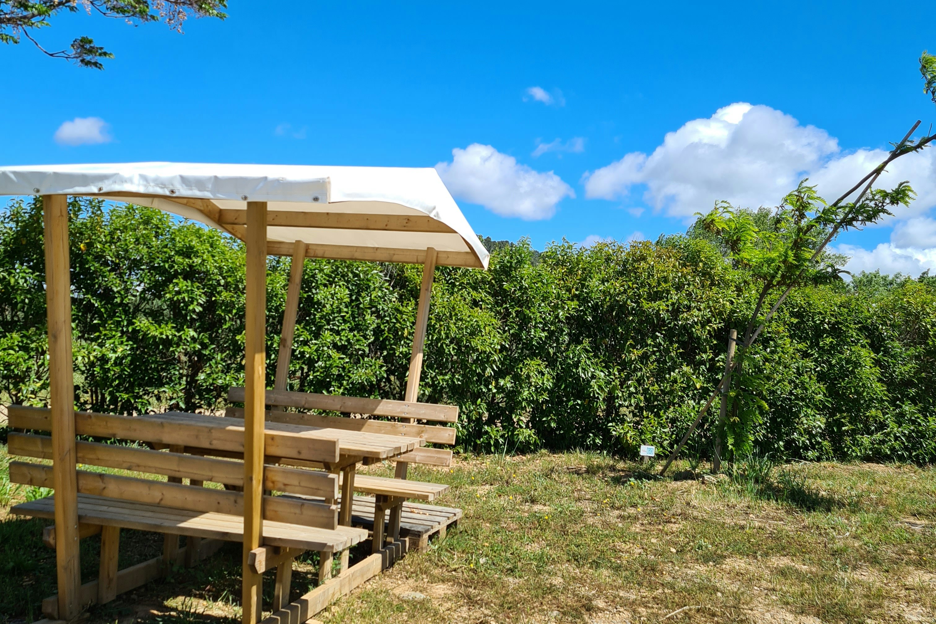 Flower Camping Olivigne - Überdachte Sitzecke im grünen auf dem Campingplatz