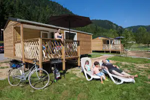 Flower Camping Verte Vallee - Mobilheime vom Campingplatz mit Veranden und Liegestühlen auf grüner Wiese