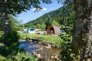 Flower Camping Verte Vallee - Blick auf den Stellplatz und ein Mobilheim mit direktem Zugang zum Fluss am Campingplatz