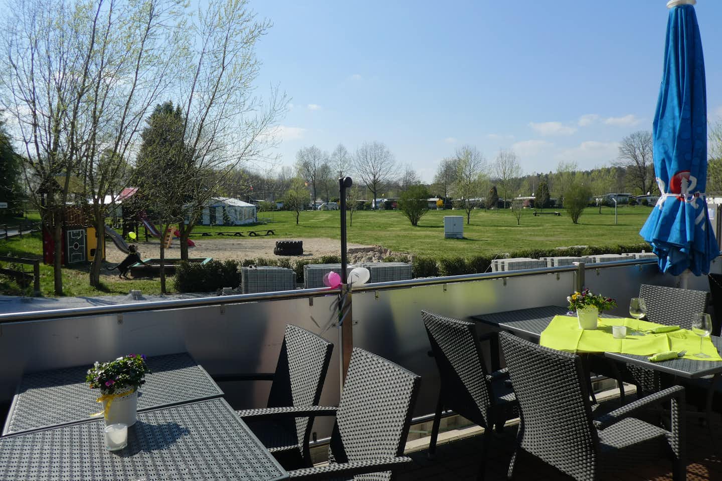 Freizeit- und Wohnpark am Lippesee - Terrasse mit Tischen und Blick auf den Spielplatz 