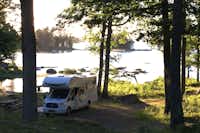Getnö Gård Naturcamping  -  Wohnwagenstellplatz vom Campingplatz zwischen Bäumen mit Blick und direktem Zugang zum See