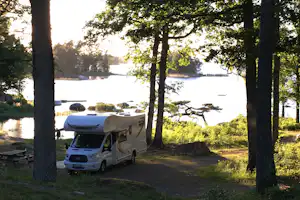 Getnö Gård Naturcamping - Wohnwagenstellplatz vom Campingplatz zwischen Bäumen mit Blick und direktem Zugang zum See