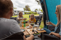 DCU-Camping Gjerrild Strand  Gjerrild Nordstrand Camping - Gäste beim gemeinsamen Essen auf ihrem Stellplatz