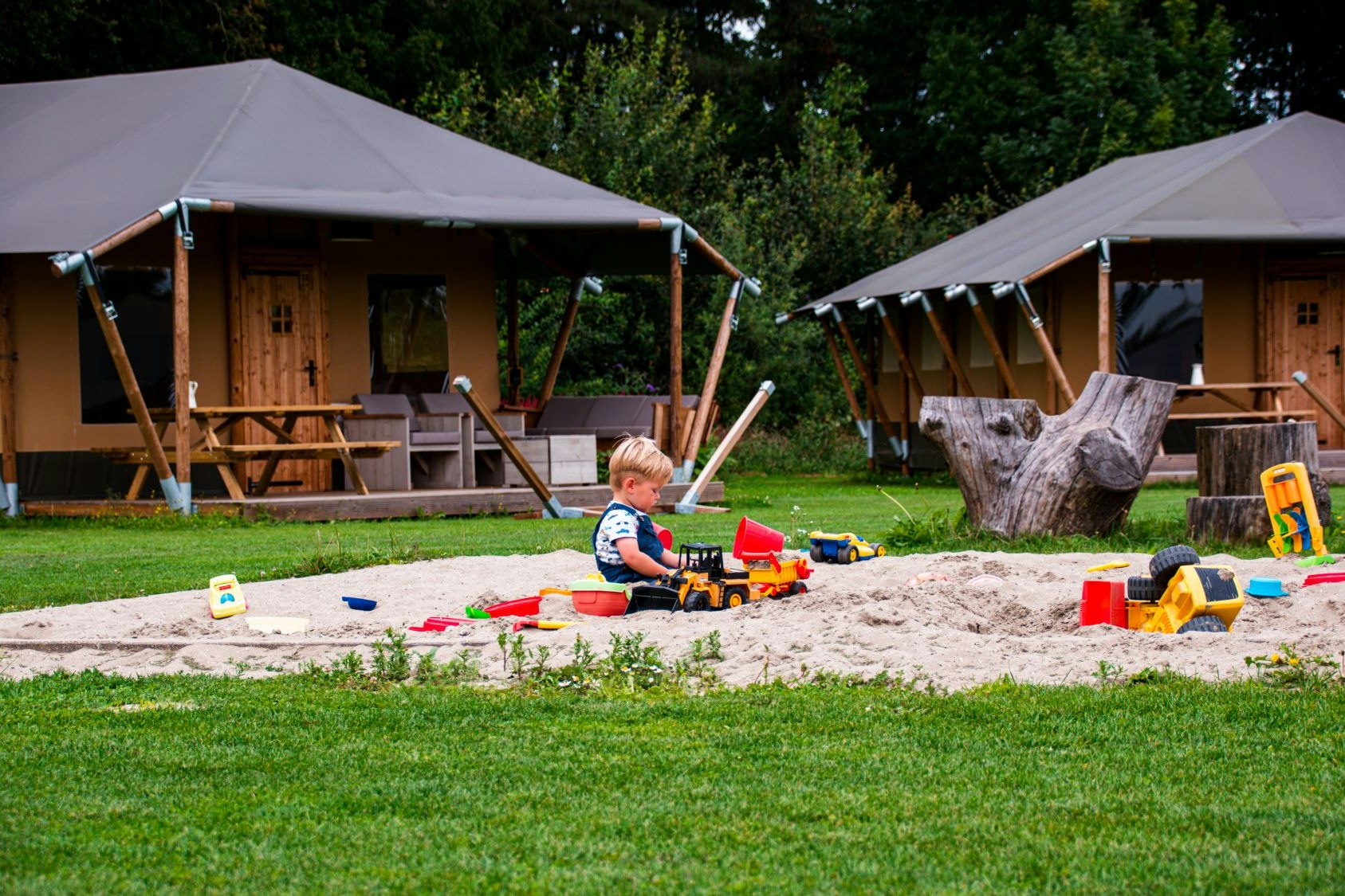 Glamping de Bosweide - Kinder spielen im Sandkasten vor den Glamping-Unterkünften