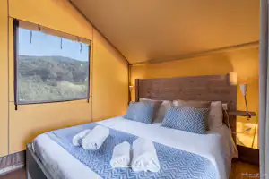 Glamping Tuscany - Podere Cortesi - Doppelbett im Schlafzimmer eines Mobilheims