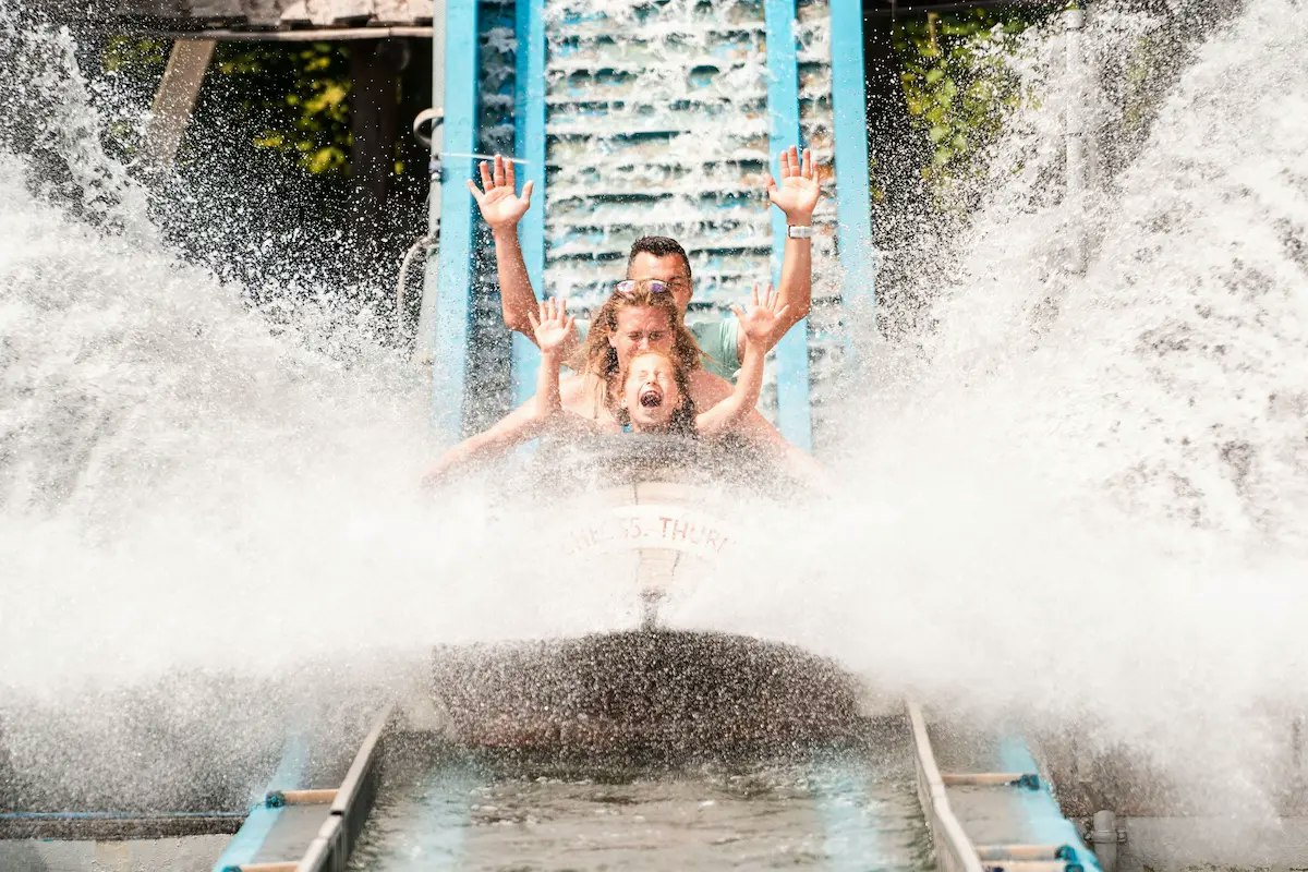 Ein Mann steht im Whirlpool und hält sich an den Griffen fest, während Wasserfontänen und Sprühnebel aufsteigen.