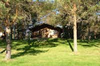 Haapasaaren Lomakylä  -  Mobilheim vom Campingplatz im Schatten von Bäumen