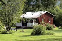 Hammarstrands Camping, Stugby och Fiske -  Mietunterkunft mit Terrasse umgeben von kleinen Bäumen und Sträuchern