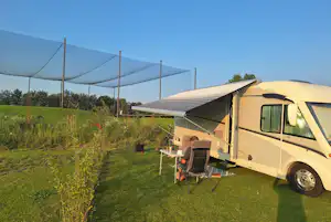 Harderwold Villa Resort - Camper sitzt vor seinem Wohnmobil auf seinem Standplatz