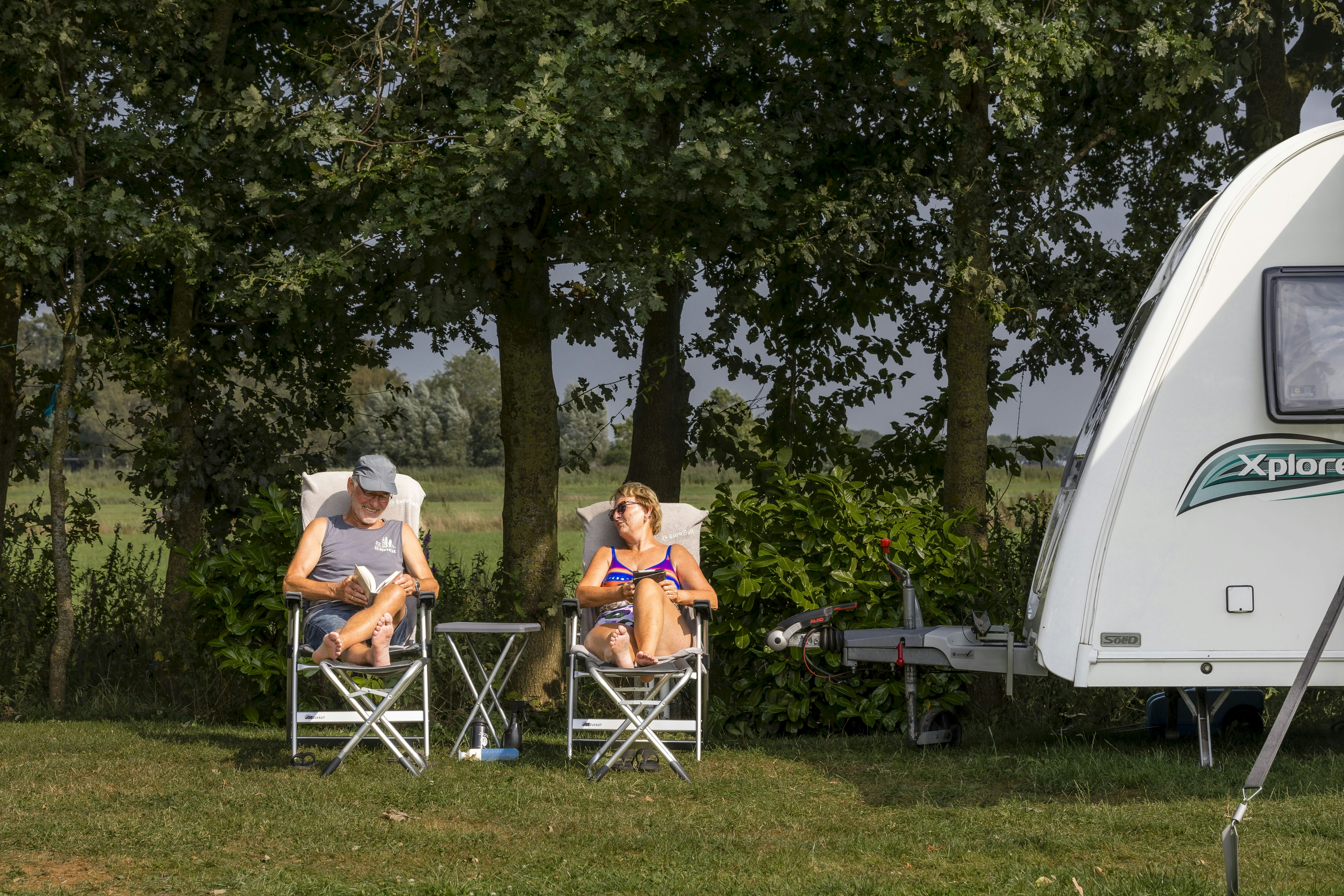Camping De Bolderik  Het Zwerversnest - Camper entspannen auf Campingstühlen auf ihrem Standplatz