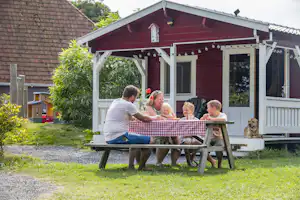 Camping De Bolderik Het Zwerversnest - Familie sitzt an einem Picknicktisch auf dem Campingplatz