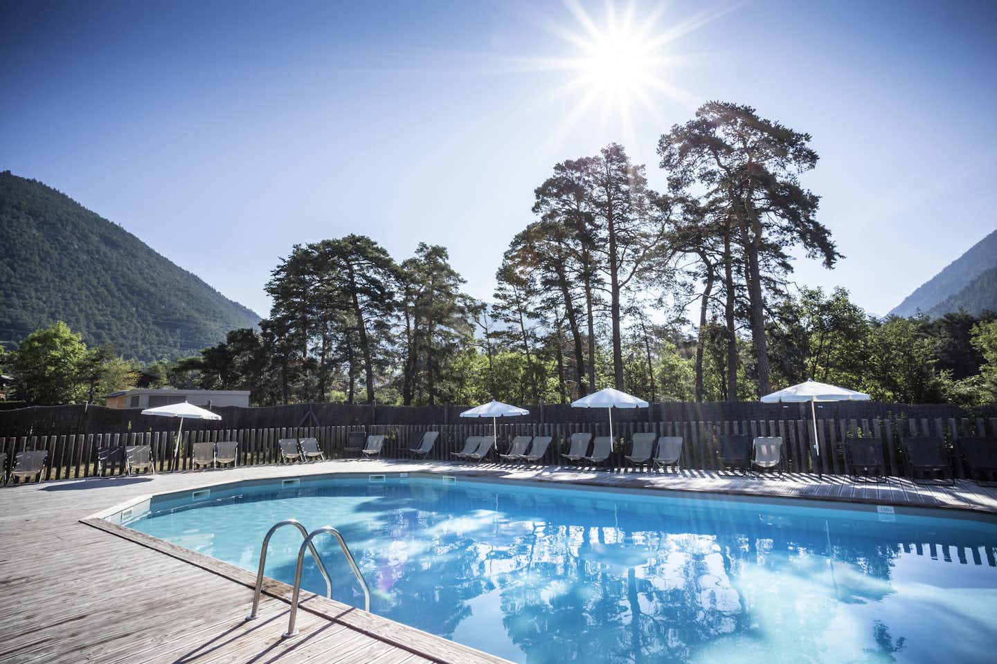 Huttopia Bourg-Saint-Maurice - Pool im Freien mit Liegestühlen und Sonnenschirmen