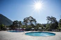 Huttopia Camping Bourg Saint Maurice - Pool mit Liegestühlen und Sonnenschirmen auf dem Campingplatz