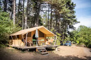 Huttopia Camping Divonne Les Bains - Blick auf ein Glamping-Zelt am Waldrand