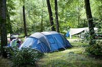 Huttopia Camping Douarnenez - Grüner Zeltplatz im Schatten der Bäume auf dem Campingplatz