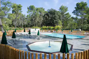 Huttopia Camping Fontvieille - Pool mit Liegestühlen und Sonnenschirmen auf dem Campingplatz