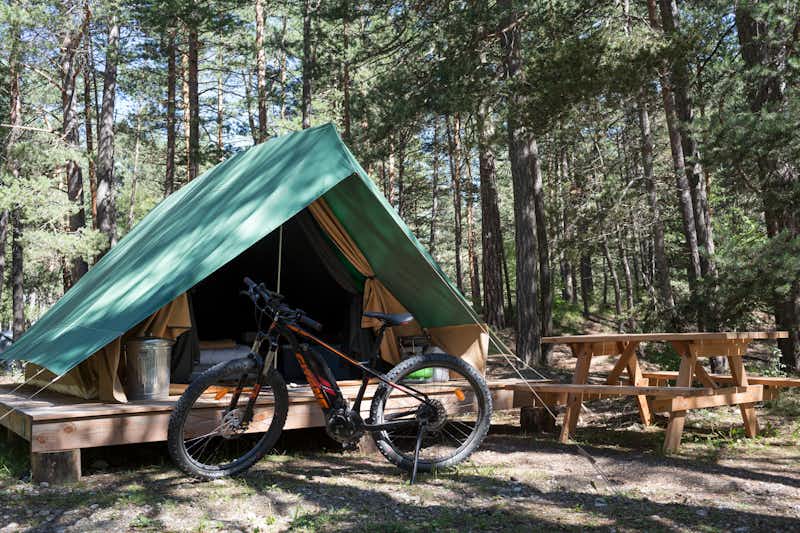 Huttopia Camping La Clarée - Fahrrad vor Glamping Zelt mit Esstisch auf dem Gelände vom Campingplatz