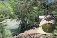 Huttopia Camping La Clarée - Zeltplatz im Schatten der Bäume mit Blick auf Fluss auf dem Campingplatz