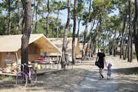 Huttopia Camping Noirmoutier - Spazierweg zwischen den Bäumen auf dem Campingplatz