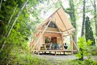 Huttopia Camping Rambouillet - Glamping Zelt mit Veranda zwischen den Bäumen auf dem Campingplatz
