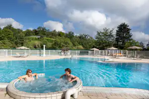 Huttopia Camping Royat - Pool im Freien mit Liegestühlen und Sonnenschirmen