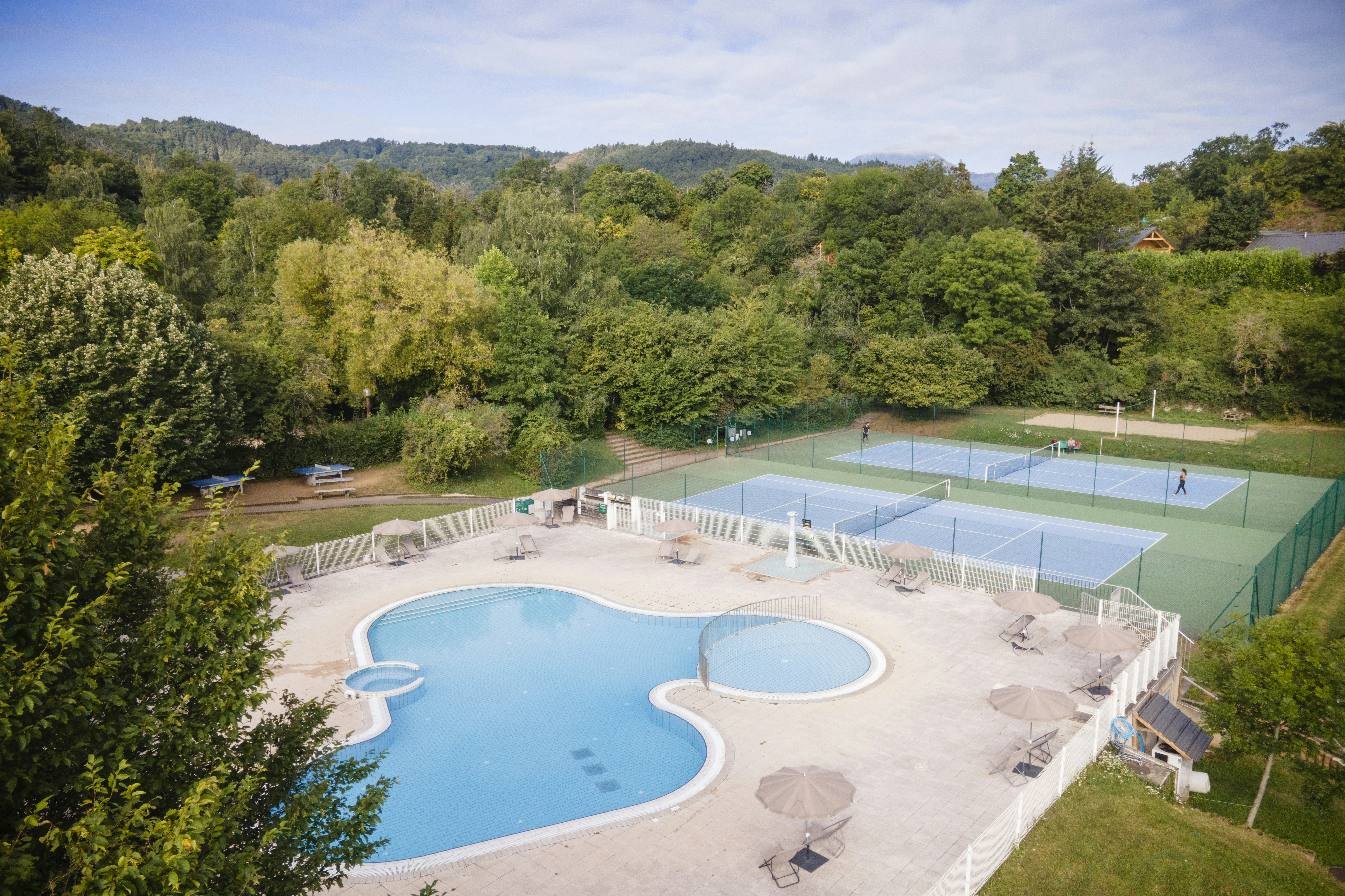 Huttopia Royat  Huttopia Camping Royat - Blick auf den Pool und die Tennisplätze auf dem Campingplatz