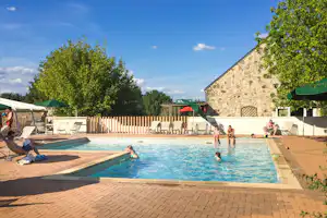 Huttopia Camping Saumur - Sonniger Poolbereich mit Liegestühlen und Sonnenschirmen auf dem Campingplatz