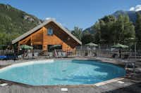 Huttopia Camping Vallouise - Pool im Freien mit Liegestühlen und Sonnenschirmen