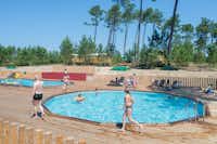Huttopia Landes Sud - Poolbereich vom Campingplatz mit Planschbecken Liegestühlen und Sonnenschirmen