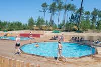 Huttopia Landes Sud - Poolbereich vom Campingplatz mit Planschbecken Liegestühlen und Sonnenschirmen