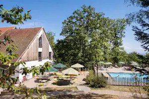 Huttopia Wattwiller - Pool im Freien mit Liegestühlen und Sonnenschirmen