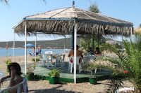 Hydra's Wave Camping - Strand mit Pavillon und Sitzgelegenheiten mit Blick auf das Mittelmeer